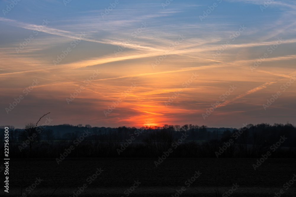 Sonnenuntergang auf dem Land. Orangener  und blauer Himmel in Münster, Deutschlang