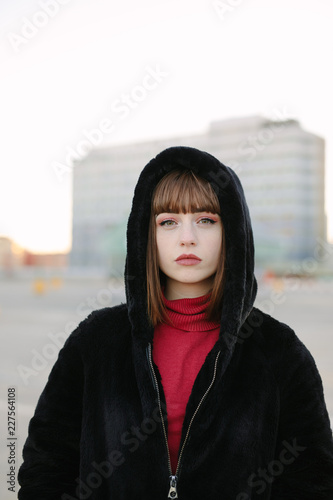 Beautiful young girl in black coat photo