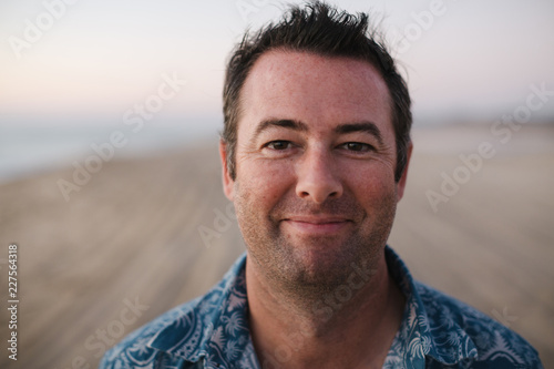Smiling, content man on beach at sunset