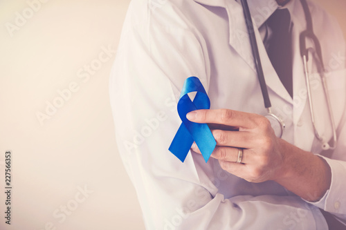 Doctor hands holding blue ribbon, diabetes and Colorectal Cancer Awareness