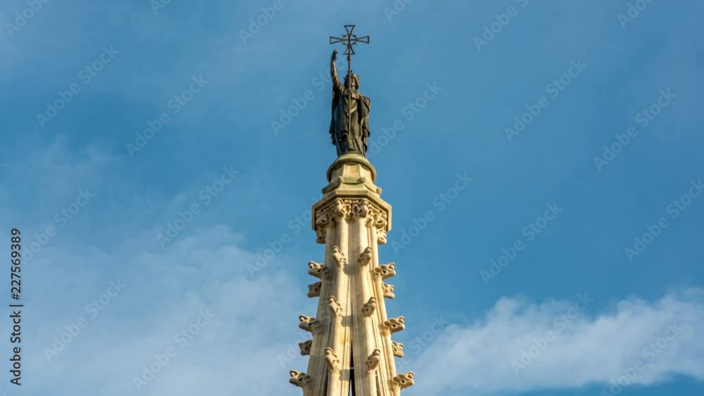 Statue at top of the Cathedral of the Holy Cross and Saint Eulalia located in Gothic quarter of Barcelona. White clouds move across blue sky. Time lapse video. Statue at top of the Cathedral of the Holy Cross and Saint Eulalia located in Gothic quarter of Barcelona. White clouds move across blue sky. Time lapse video.