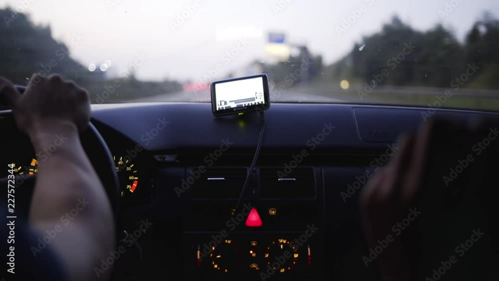 Car driving on a highway frame focused on dashboard with colorful metering lights and bright gps navigator