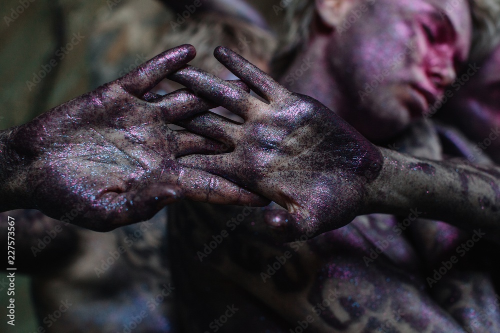 Crop sparkling violet hands and unfocused faces behind them Crop sparkling violet hands and unfocused faces behind them