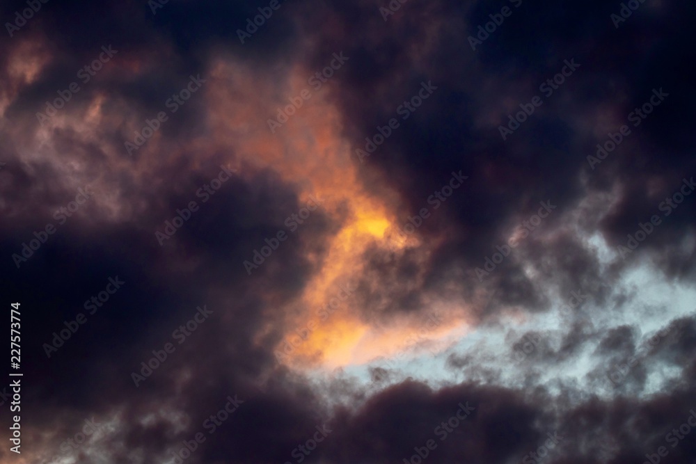 Dramatic sky with orange sun and black clouds