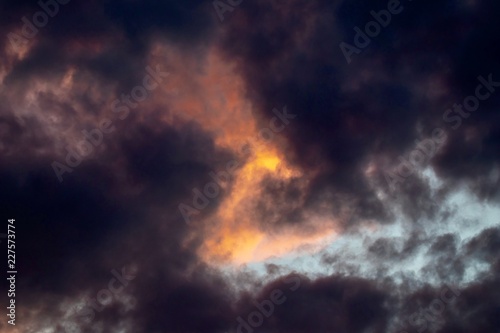 Dramatic sky with orange sun and black clouds