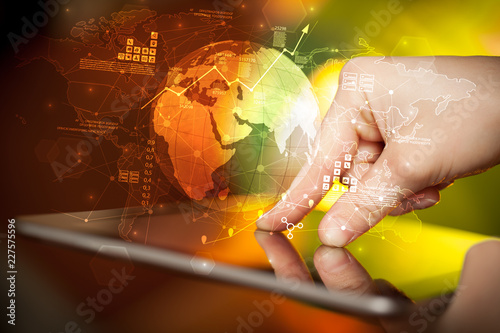 Hand using tablet with multinational worldwide estate report concept
 photo