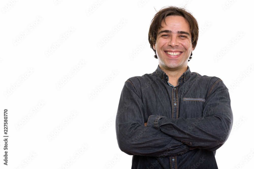 Studio shot of young happy Persian man smiling with arms crossed Studio shot of young happy Persian man smiling with arms crossed