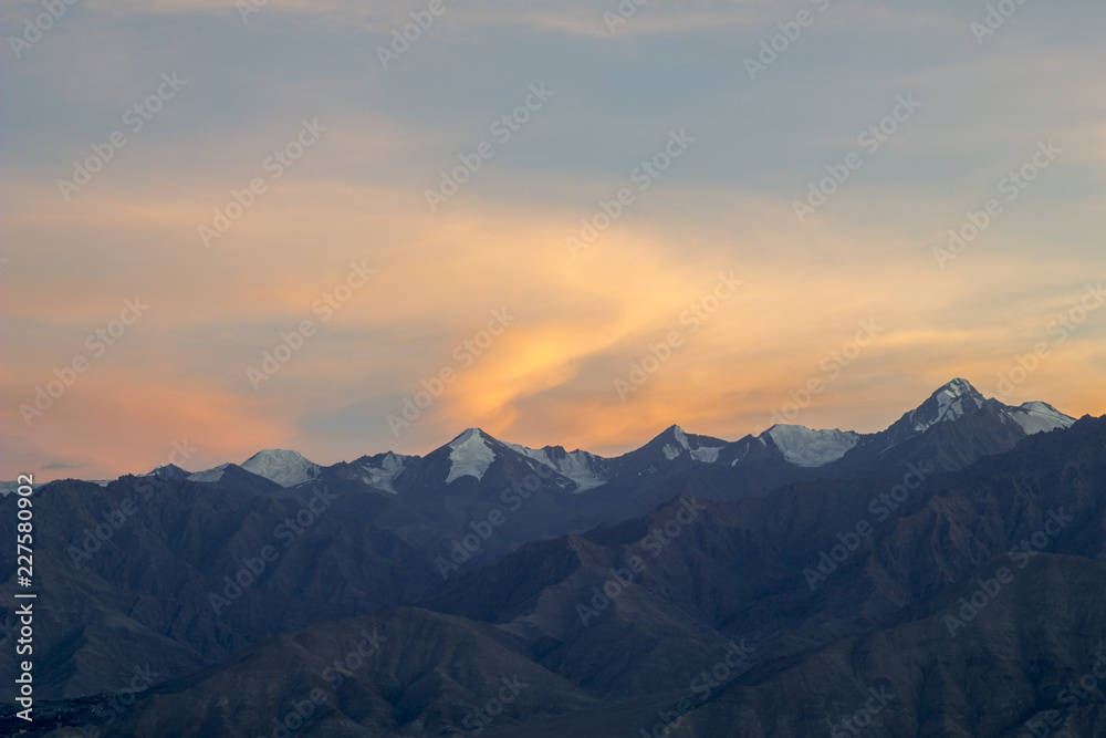 pink orange sunset over the mountains with snowy peaks