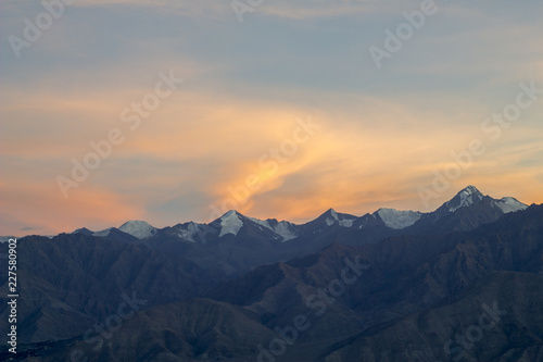 pink orange sunset over the mountains with snowy peaks