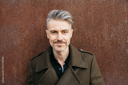 Handsome man in fashionable coat with grey hair.