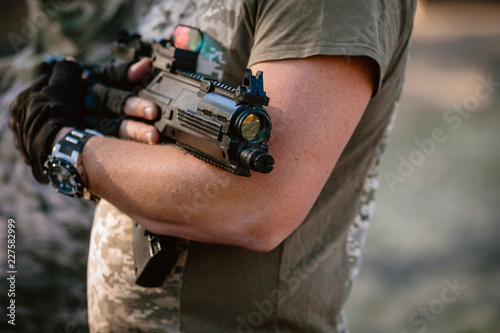 Closeup photo of lasertag player holding optical gun