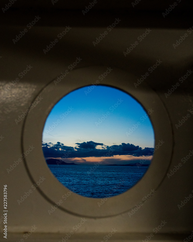 Dusk viewed from a round port on a ship Dusk viewed from a round port on a ship