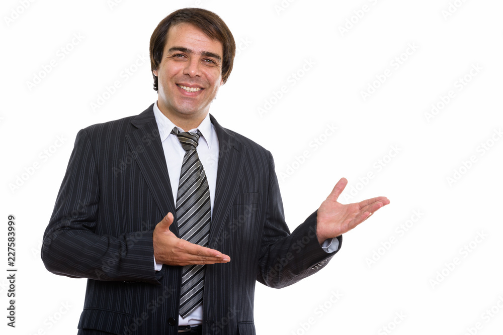 Studio shot of young happy Persian businessman smiling while sho Studio shot of young happy Persian businessman smiling while sho