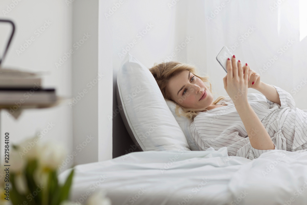 Woman Using Cell Phone in Her Bed Woman Using Cell Phone in Her Bed