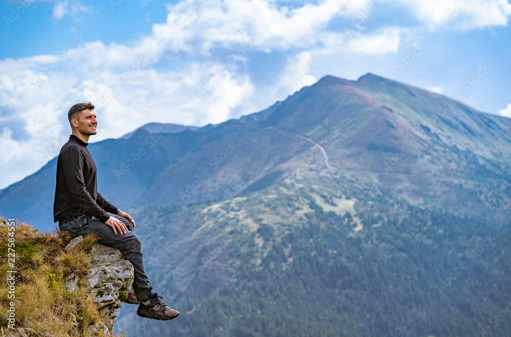 The happy man sitting on the cliff The happy man sitting on the cliff