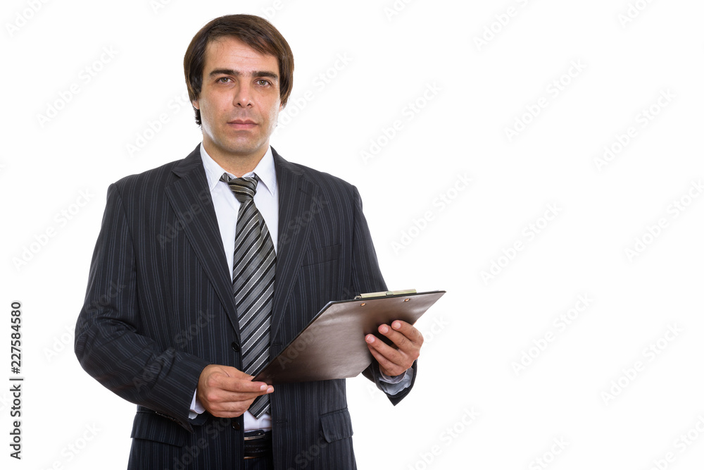 Studio shot of young Persian businessman holding clipboard Studio shot of young Persian businessman holding clipboard