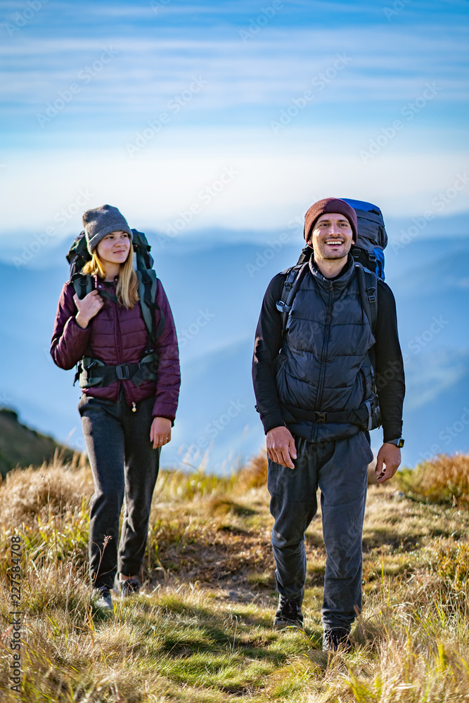 The happy woman and a man walking on the mountain