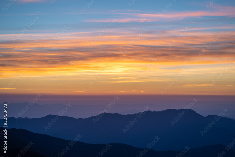 The picturesque mountain landscape on the sunset background