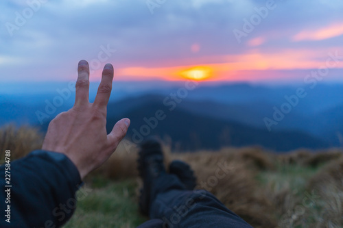 The hand gesturing on the beautiful mountain landscape background