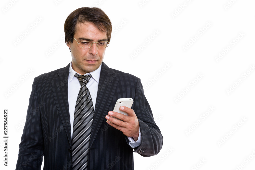 Studio shot of young Persian businessman using mobile phone Studio shot of young Persian businessman using mobile phone