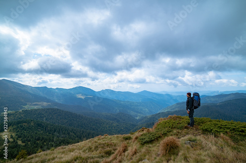 The man standing on the mountain on the cloud background