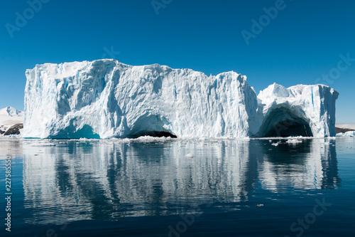 Photos Large weathered iceberg with caves reflected in glassy water, Cierva Cove, Antar