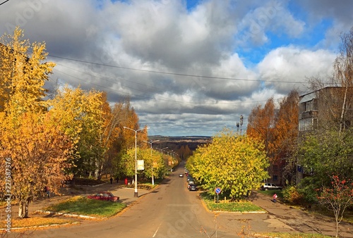 Beautiful clouds over the city with yellow trees in autumn