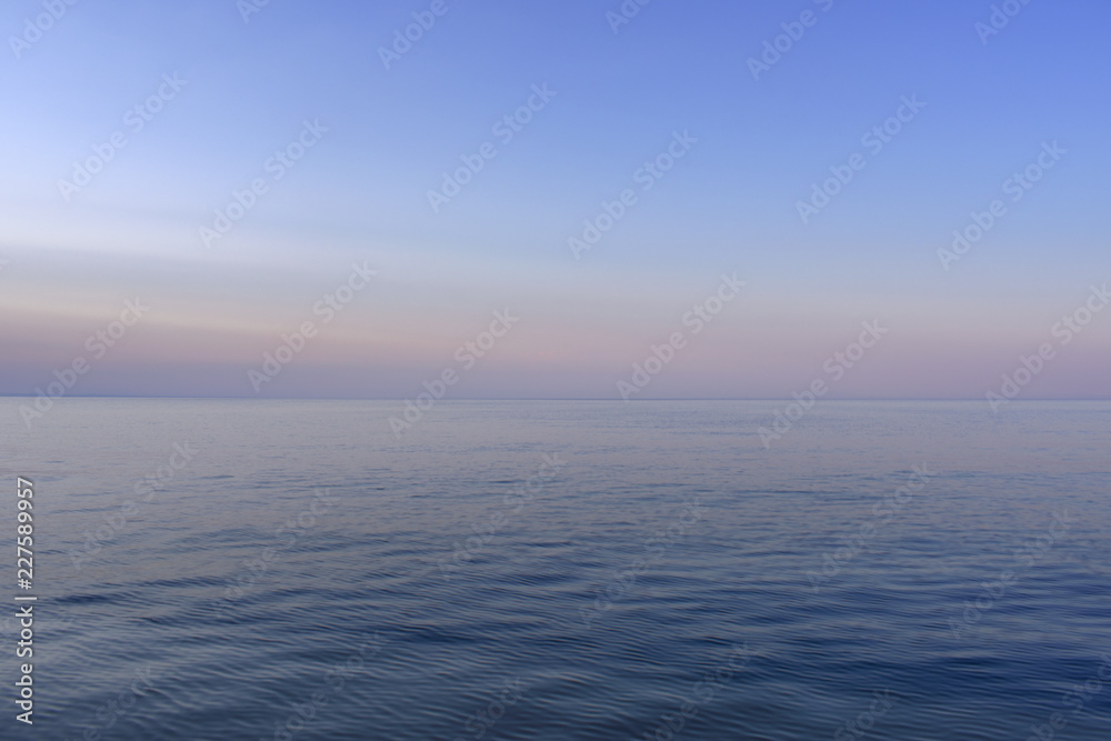 The calm sea with the purple colors of the sky