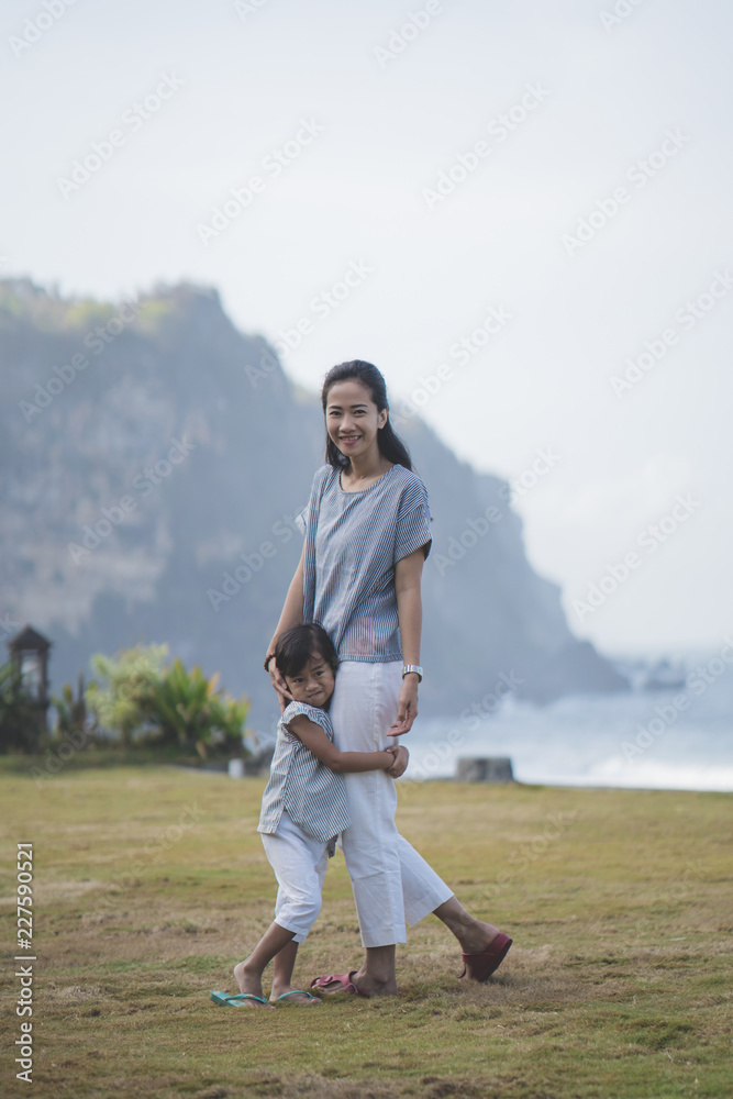asian woman and his daughter walking around park looking at came asian woman and his daughter walking around park looking at came