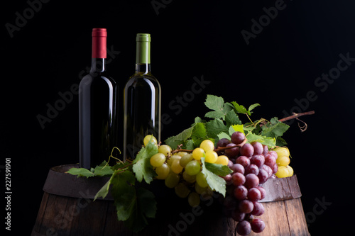 Wine bottles and a glass on a barrel