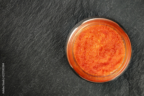 Murais de parede Red fish roe in a jar, shot from above on a black background with copy space