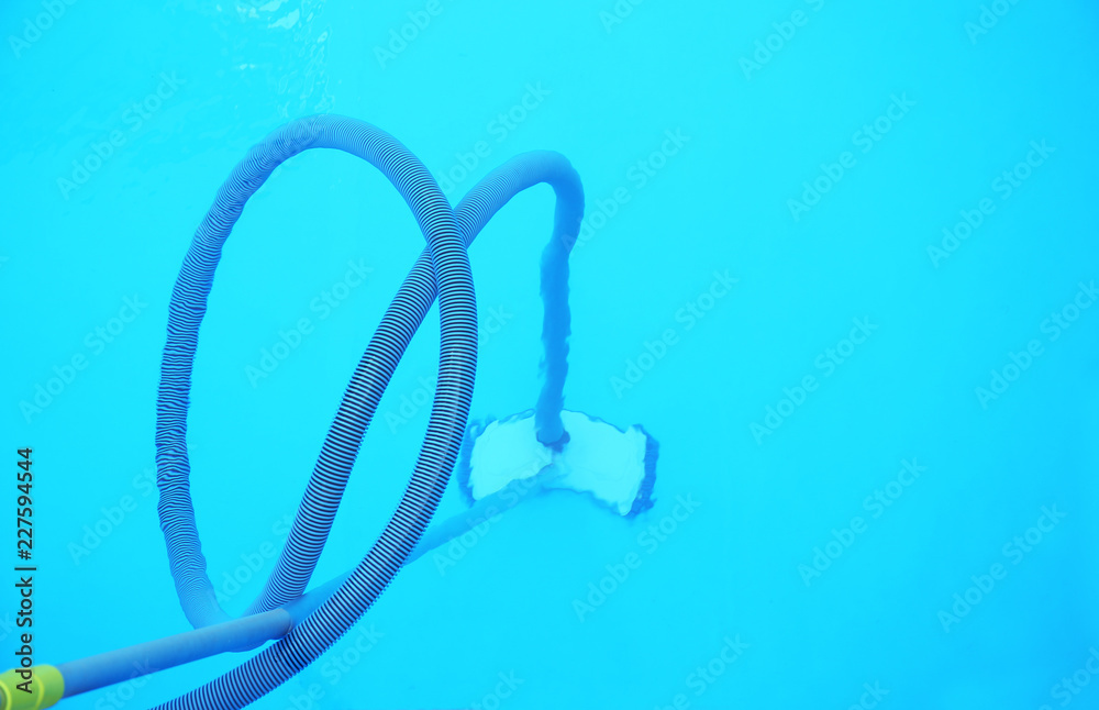 Cleaning outdoor pool with underwater vacuum, closeup Cleaning outdoor pool with underwater vacuum, closeup