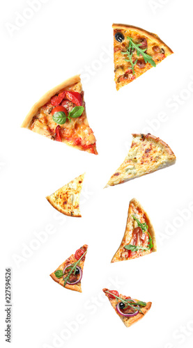 Set with falling different pizza slices on white background