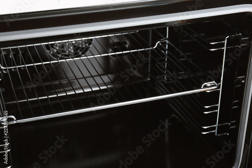 Open empty electric oven with rack, closeup