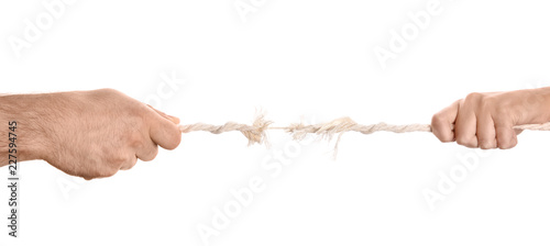 Foto Man and woman pulling frayed rope at breaking point on white background