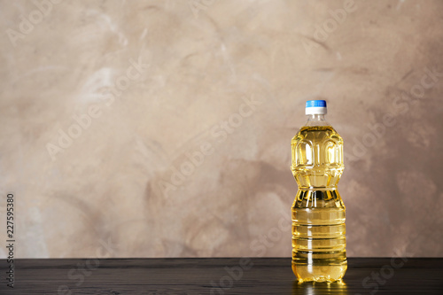 Fototapeta Naklejka Na Ścianę i Meble -  Bottle of oil on table against color background. Space for text