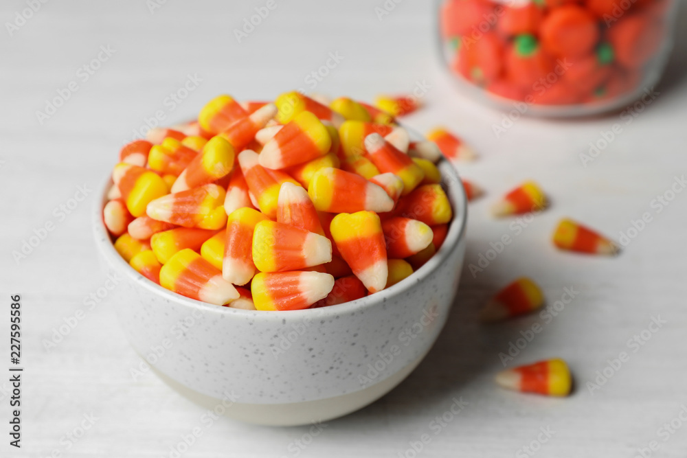 Bowl with tasty candy corns on table, closeup