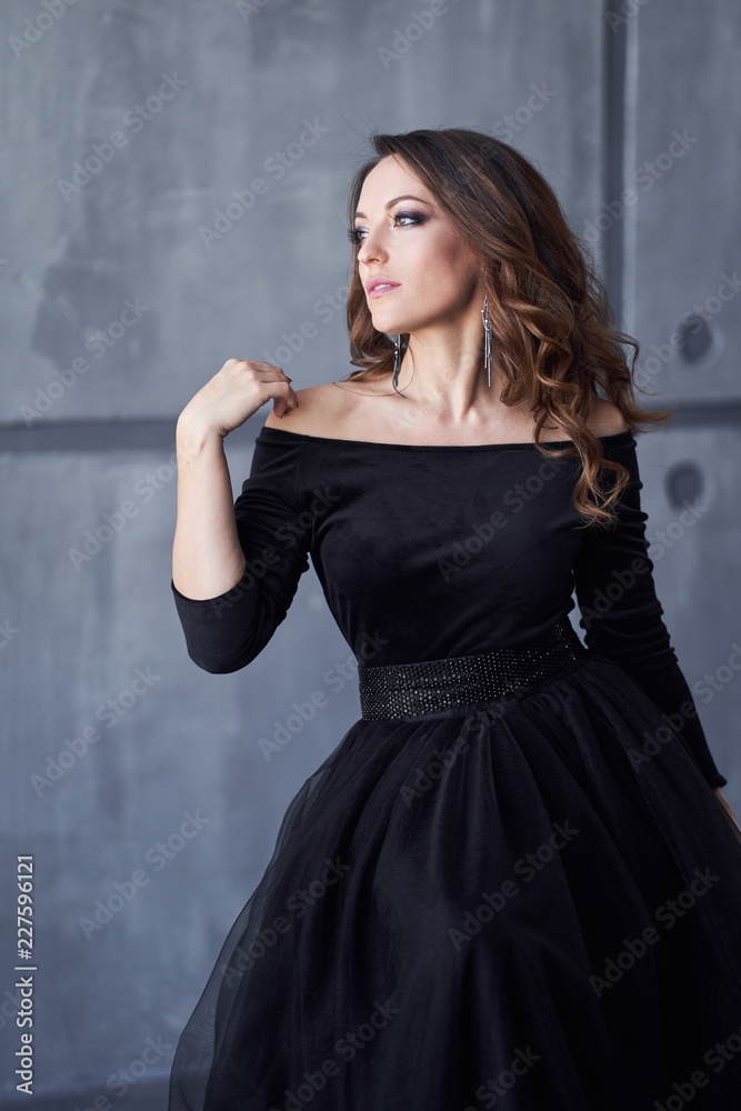 Beautiful girl with makeup and hairdo in a black dress Beautiful girl with makeup and hairdo in a black dress