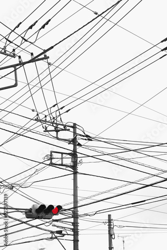 red light, power lines, power poles and cloudy sky