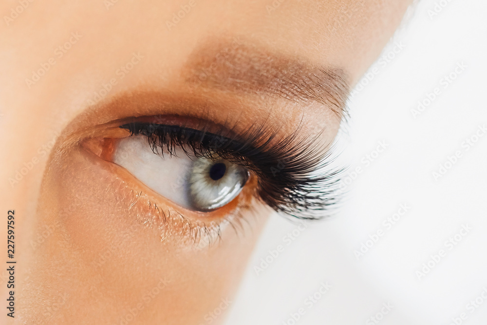 Naklejka premium Female eye with extreme long false eyelashes. Eyelash extensions, make-up, cosmetics, beauty