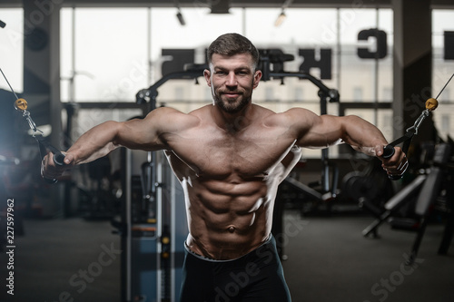 Brutal strong bodybuilder athletic men pumping up muscles with dumbbells © antondotsenko