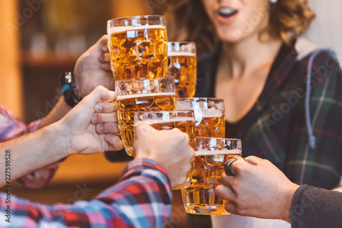 Photography Group of six friends wowing and making cheers with beer pints