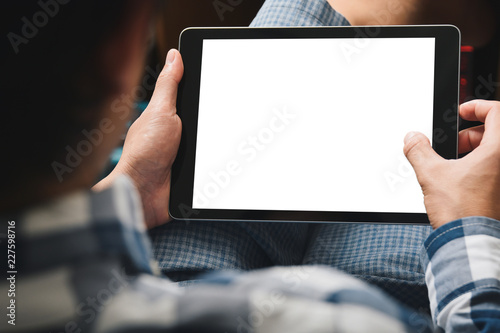 Mockup tablet image, Man using tablet computer while sitting relax on chair with Clipping path on screen for easy replace you design mock up photo