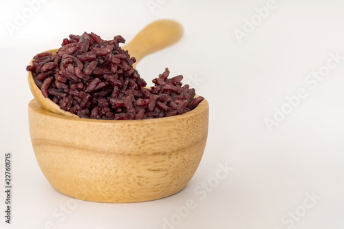 Wooden bowl and spoon with brown rice ready to eat on selective focus. Deep Purple rice, Homnil rice. photo