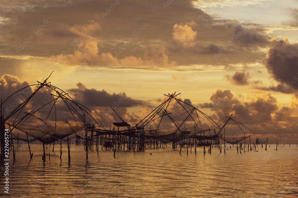 Traditional fishing nets over cloudy sunrise at Phatthalung, Thailand.