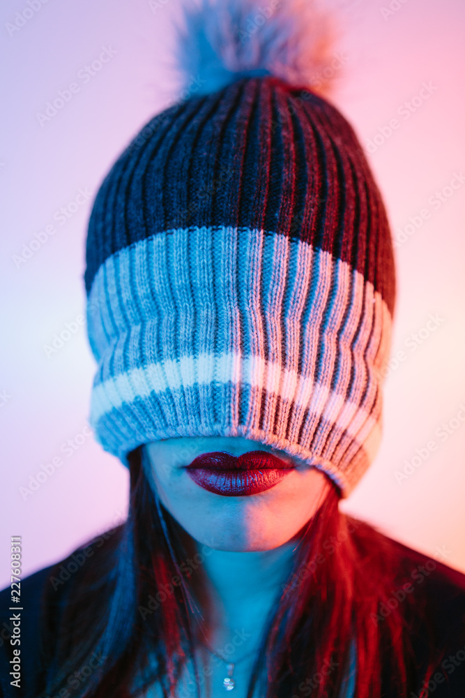 Anonymous woman with her head covered by a winter hat with only her red lips showing Anonymous woman with her head covered by a winter hat with only her red lips showing