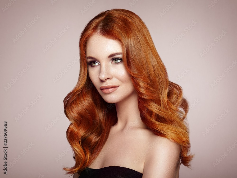Naklejka premium Redhead Girl with Long Healthy and Shiny Curly Hair. Care and Beauty. Beautiful Model Woman with Wavy Hairstyle. Make-Up and Black Dress