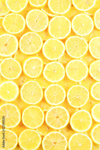 A slices of fresh juicy yellow lemons.  Texture background, pattern.
