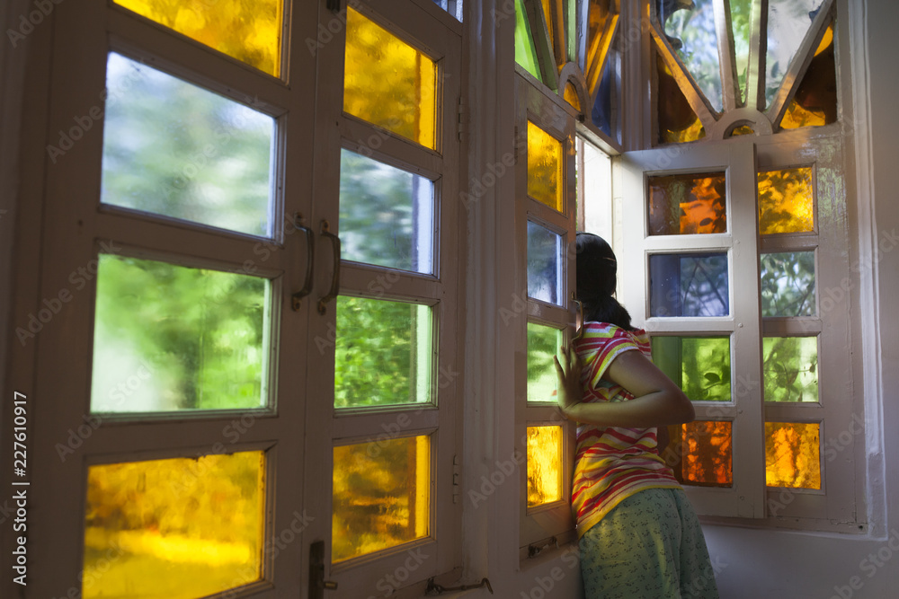 A girl looking through a colorful window A girl looking through a colorful window