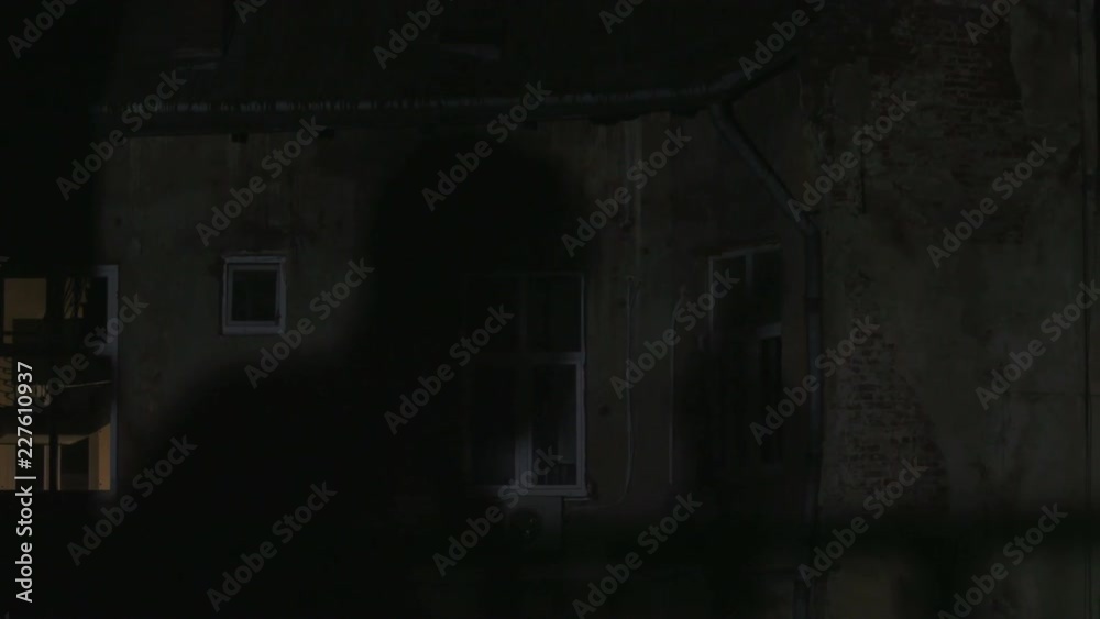Shadow of man with gun reflecting on house. Dangerous killer trying to get into house. Lifestyle. Night time. Darkness. Shadow of man with gun reflecting on house. Dangerous killer trying to get into house. Lifestyle. Night time. Darkness.